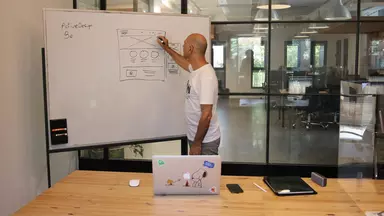 Man drawing a user interface on a whiteboard
