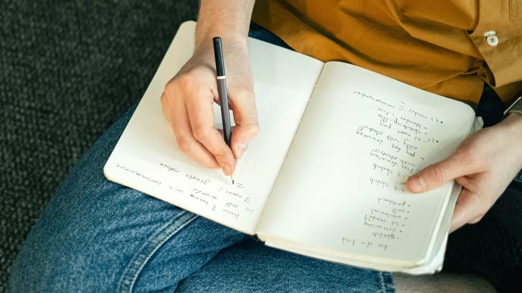 A woman sitting on the floor writing a list in a notebook